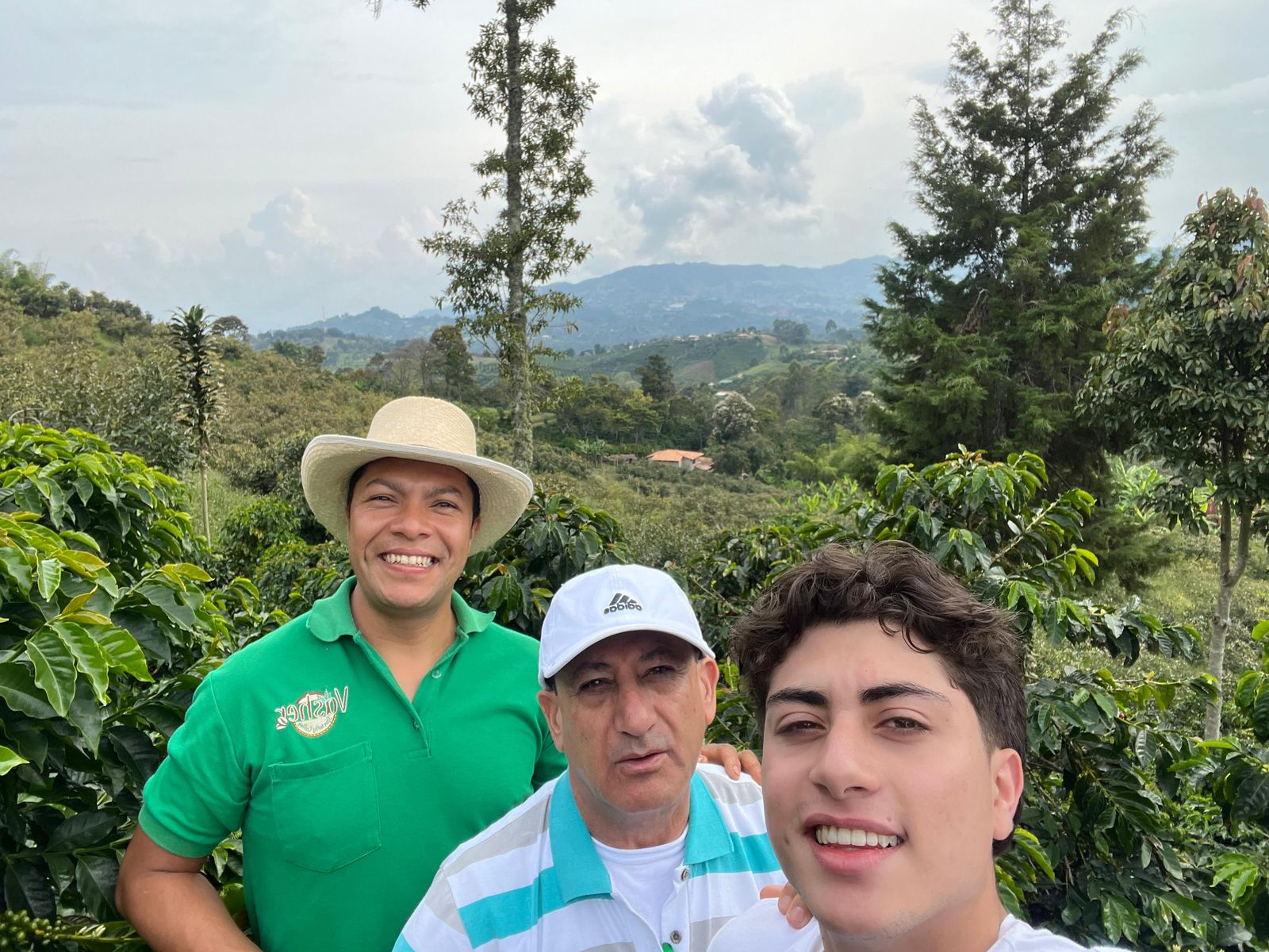 Un productor de café con Carlos Mario y su hijo en un cafetal